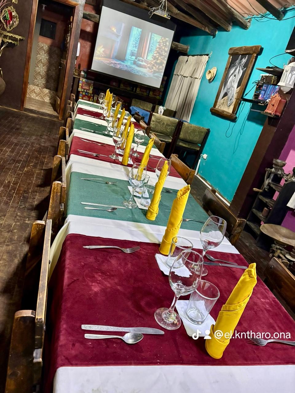 Mesas largas decoradas para un evento en el salón de El K'ntharo, con copas y manteles de colores